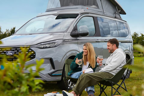 Couple relaxing outside a campervan